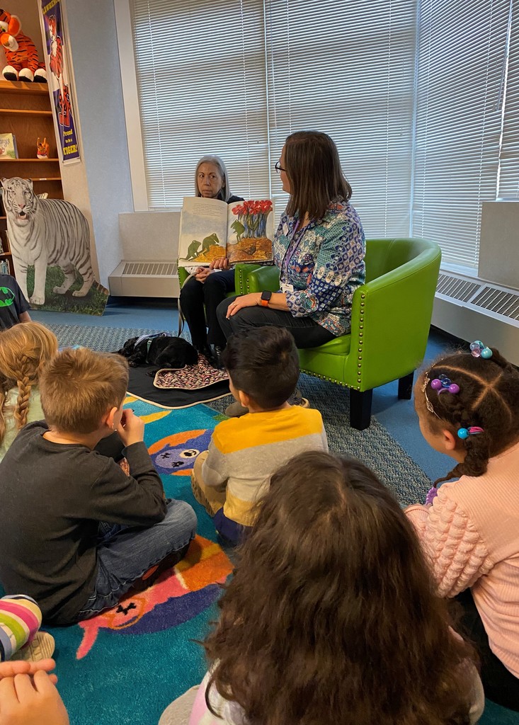 Librarian reads to a group of young students